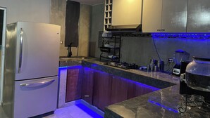 A modern kitchen with a stainless steel refrigerator, wooden cabinets, a built-in oven, and a gas stove. - House with Jacuzzi (La Paz)
