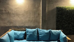 A wooden outdoor seating area with a blue sofa and a wooden table. - House with Jacuzzi (La Paz)