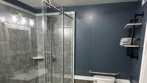 Une salle de bain moderne avec une douche à parois de verre, des toilettes et un lavabo.