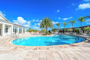 Une piscine d’un bleu éclatant, d’une profondeur de 1,37 mètre (4 pieds 6 pouces), entourée d’une terrasse carrelée et de palmiers.