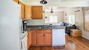 Una cocina con armarios de madera, un refrigerador blanco, una cafetera y un lavavajillas.