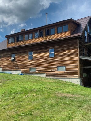 Un bâtiment moderne en bois, doté de nombreuses fenêtres et d’un toit en pente.