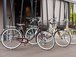 Three bicycles parked outside a building with a modern design. - Comfort Hotel Kii Tanabe (Tanabe)