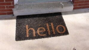 A light green door with a doormat that reads "hello" in orange letters. - Charming & Secluded Farm House (Somerset)