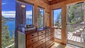 A wooden cabin with a large window offering a view of a lake and mountains. - Stunning Views at Stargazer | Lakefront Studio! (Crystal Bay)