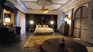 Ein Hotelzimmer mit einem Bett, einem Schreibtisch, einem runden Tisch und einem großen Spiegel.
