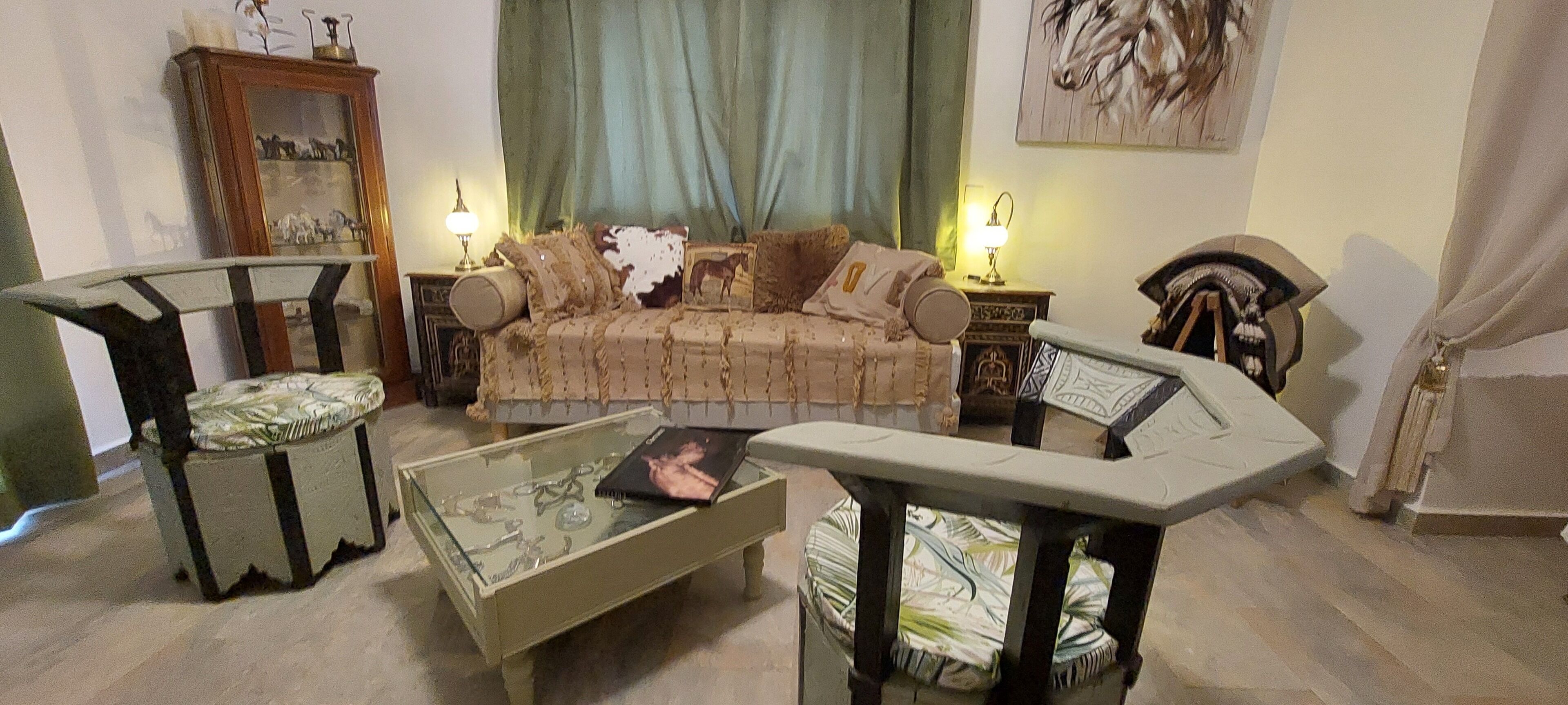 A living room with a sofa, two armchairs, a coffee table, and a cabinet.