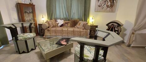 A living room with a sofa, two armchairs, a coffee table, and a cabinet.