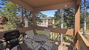 A covered outdoor area with a barbecue grill, a table, and chairs. - A Golden Getaway | Pool, Hot Tub, Tennis, & More (Truckee)