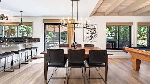 Une cuisine moderne avec un coin bar, une table à manger avec des chaises et une table de billard.