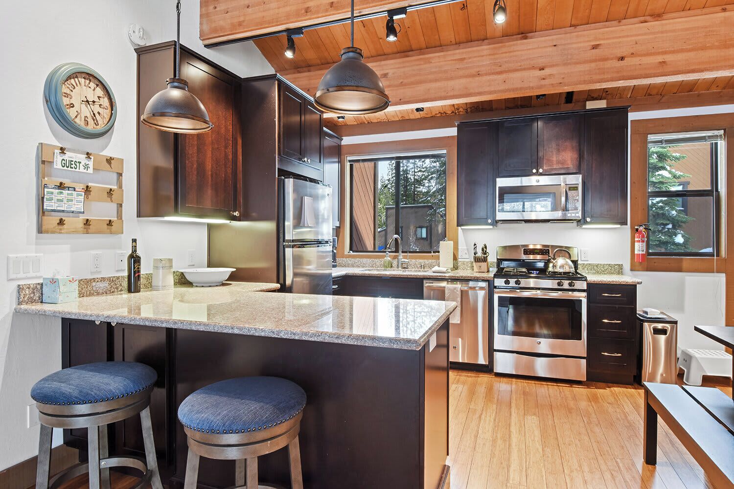 A modern kitchen with a large island, stainless steel appliances, and wooden accents.
