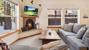 A cozy living room with a fireplace, a television, and a sofa.