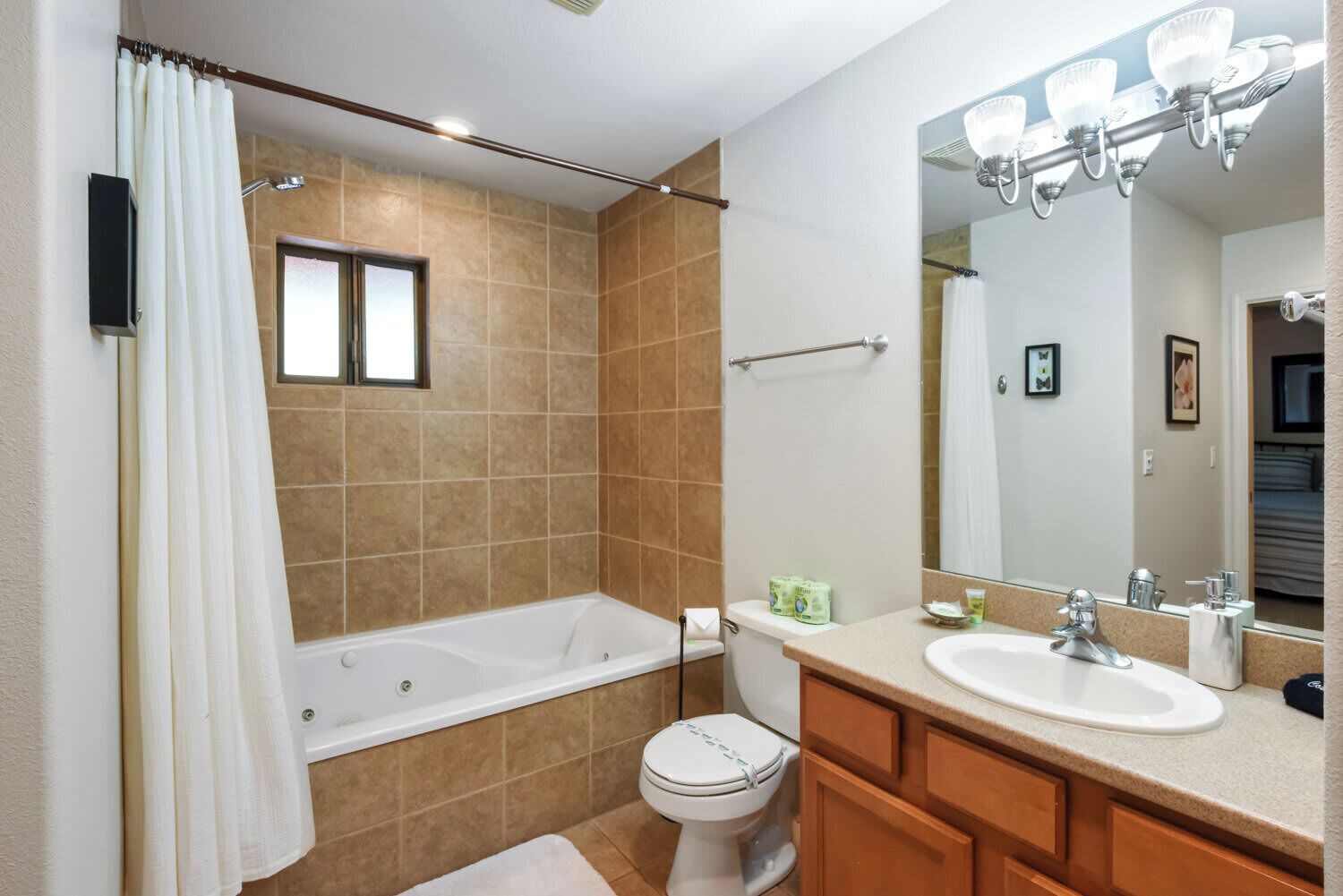 Une salle de bain équipée d’une baignoire, de toilettes et d’un meuble-lavabo avec un miroir.