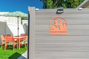A wooden fence with a logo and the text "PEACHY PARADISE" on it. -  Peachy Paradise Tiny home getaway near Raymond James & Downtown Tampa (Tampa)