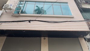 Un immeuble à plusieurs étages, doté d’un toit plat, de grandes fenêtres et d’un grand panneau avec le chiffre 7, bien visible sur la façade.