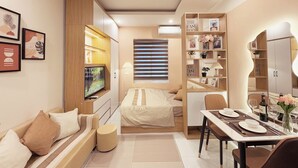 Une chambre moderne avec un lit, une table de chevet et un téléviseur. Il y a également un coin repas avec une table et des chaises.