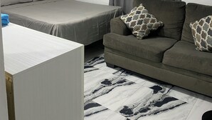 Un dormitorio con cama, sofá y escritorio.