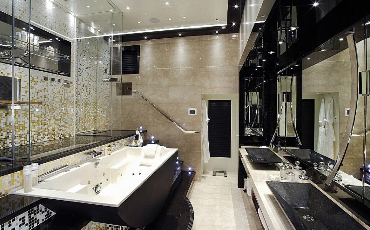 Un bagno moderno con una vasca da bagno ampia, un'area doccia vetrata e un mobile lavabo con specchio.