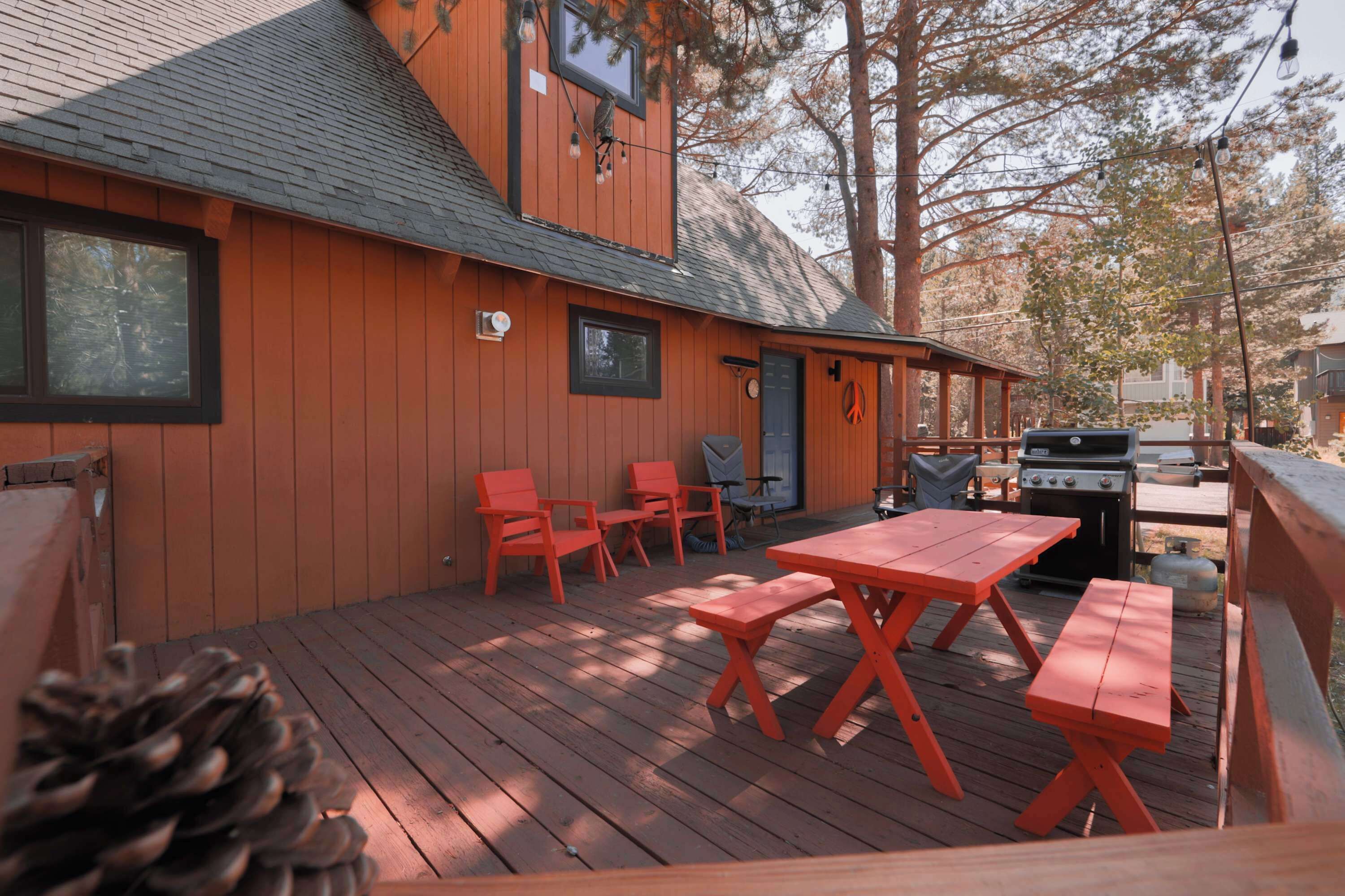 A wooden deck with outdoor seating and a barbecue grill.