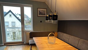 Un comedor moderno con una mesa de madera, bancos y una cesta.