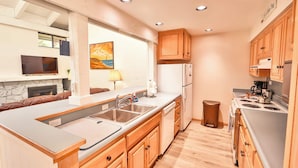 A modern kitchen with wooden cabinets, a built-in oven, and a large island with a sink.