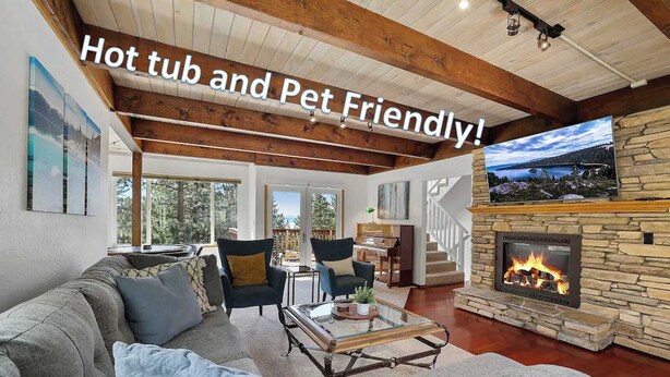 A cozy living room with a stone fireplace, comfortable seating, and a view of the outdoors. - Hall Court Manor - Hot tub, Pet Friendly, Pool Table! (Stateline)