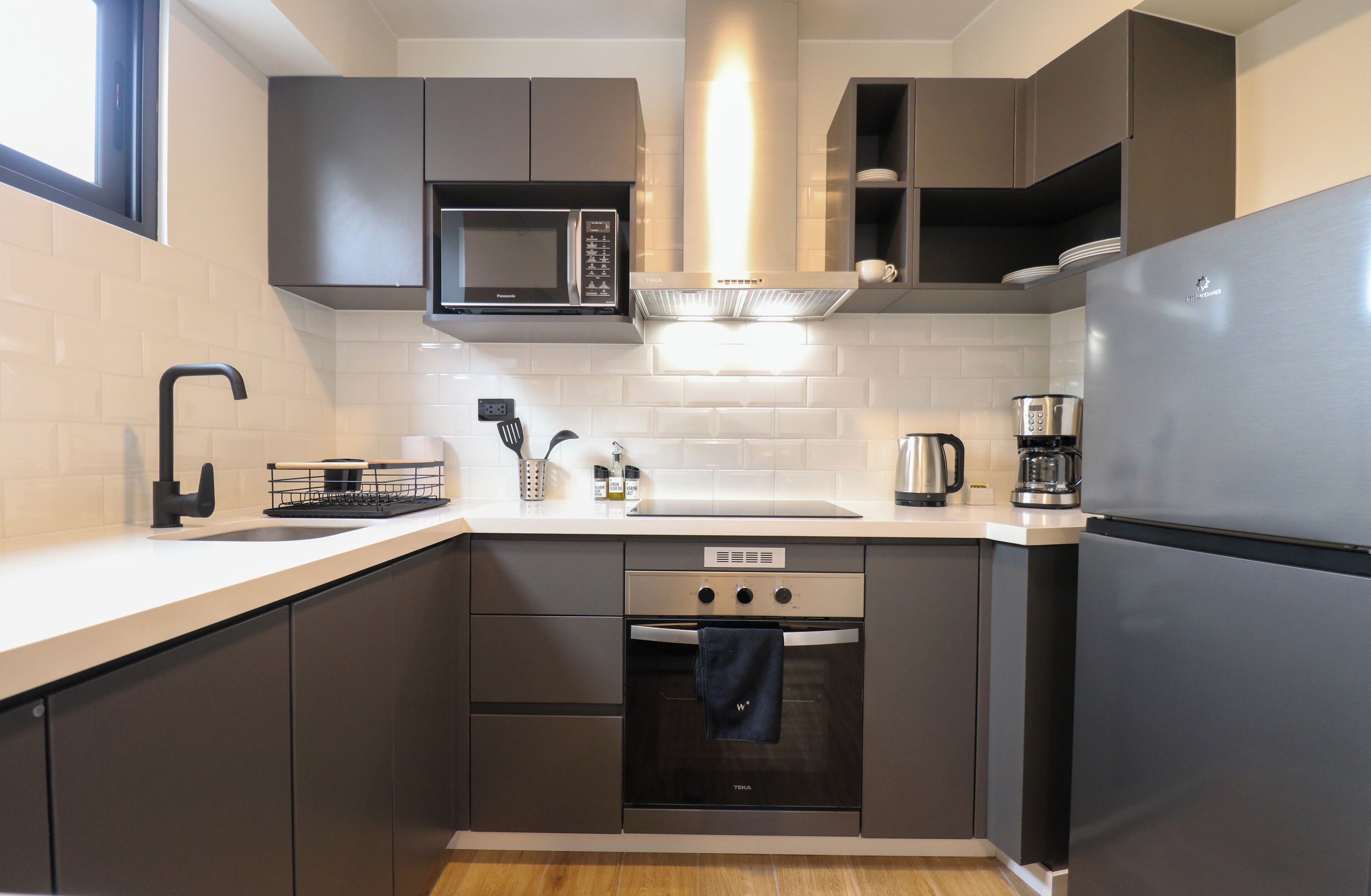 A modern kitchen with a built-in microwave, oven, and refrigerator.
