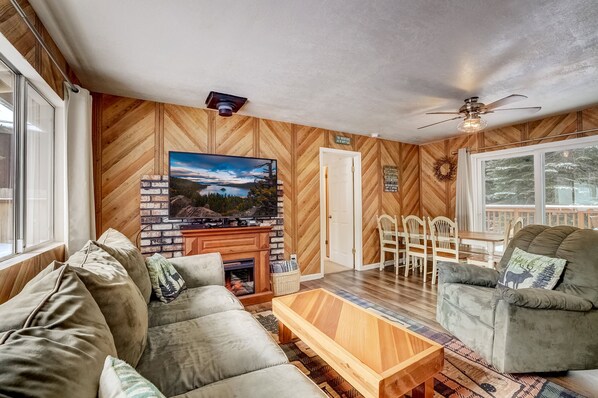 Cozy living room with fireplace, comfortable seating, and dining area.