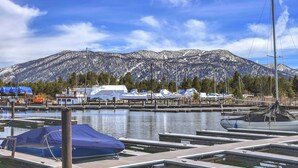 A marina with boats docked, a mountain in the background, and a clear blue sky. - Tahoe Keys Marina View: Tahoe Keys short term rental (South Lake Tahoe)