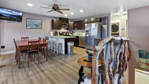 A modern kitchen with dark wood cabinets, stainless steel appliances, and a granite countertop.