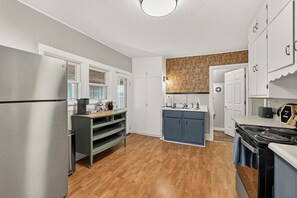 A modern kitchen with a stainless steel refrigerator, a wooden countertop, a built-in oven, and a backsplash with a patterned tile design.