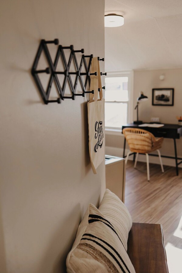 A living room with a geometric wall decoration, a wooden bench, and a cushioned sofa.