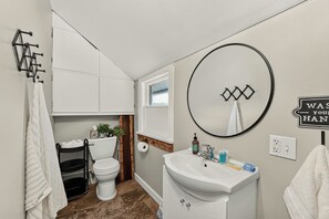 A bathroom with a toilet, sink, and towel rack.