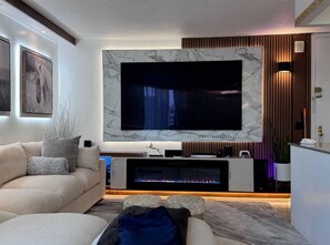 Smart TV, chimenea, libros y estéreo 
