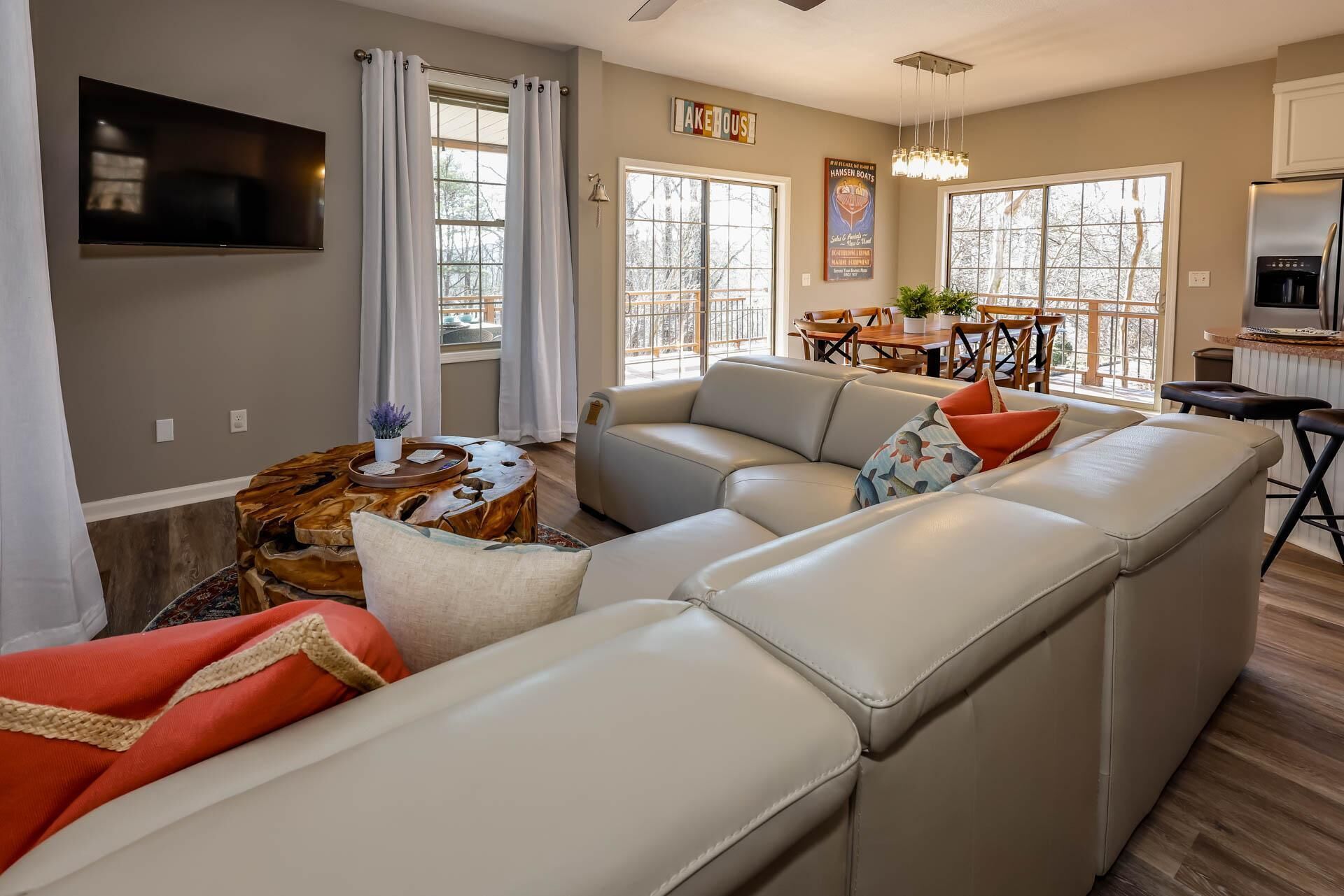 A modern living room with a sectional sofa, a coffee table, and a dining area with a table and chairs.