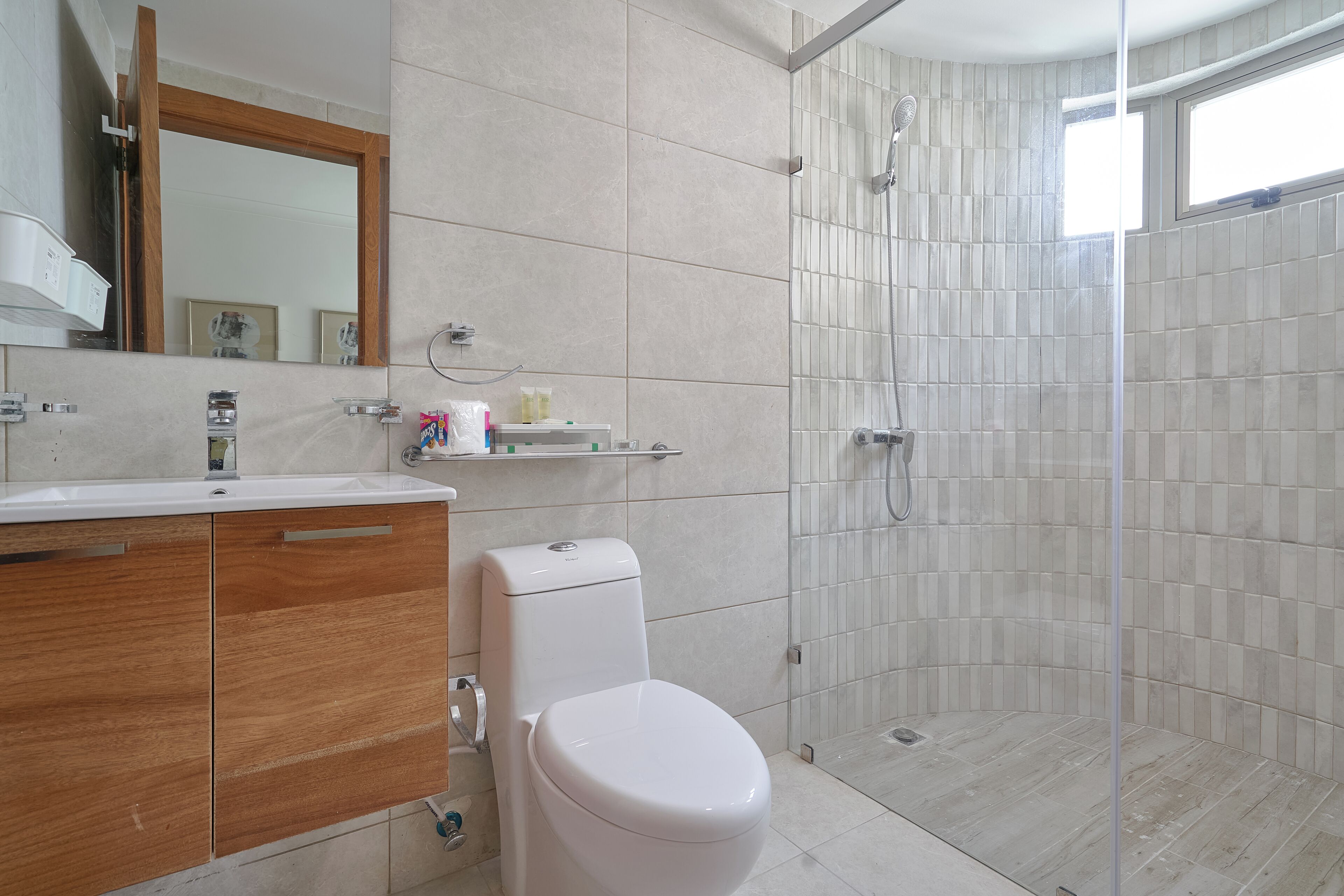 Un baño moderno con ducha, inodoro y tocador.
