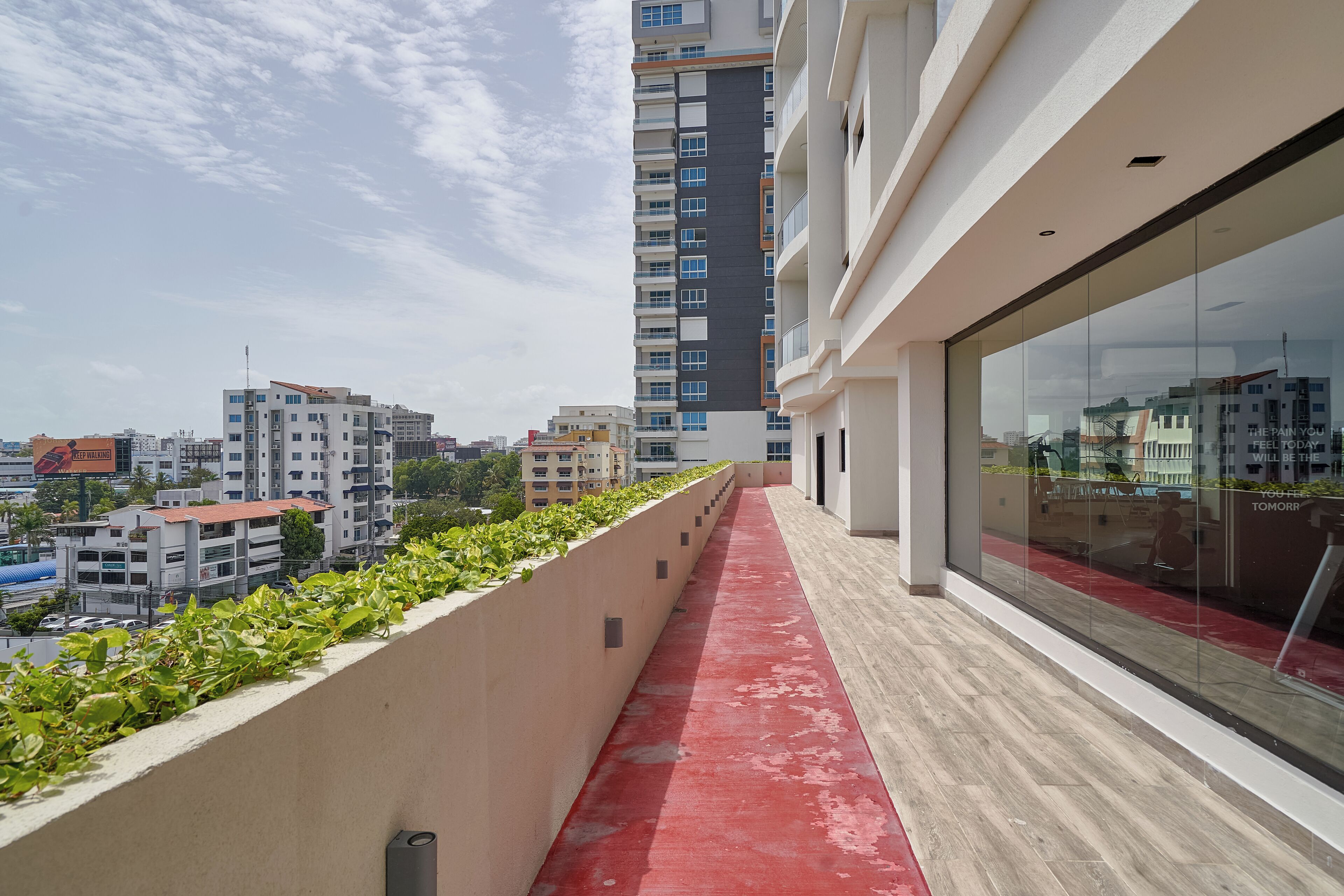 Un edificio moderno con un sendero rojo y ventanas de vidrio.