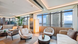 A modern hotel room with a large window, a sofa, a chair, a coffee table, and a plant. - Brickell Arch Apartment City Views & Free Parking by Palermo Home Miami (Miami)
