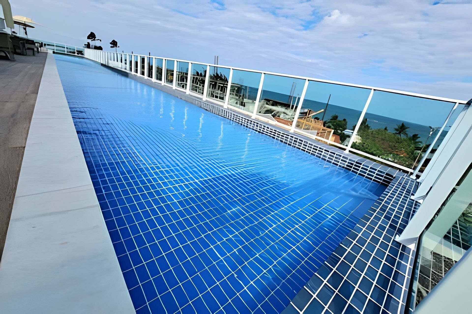 Une piscine sur le toit offrant une vue dégagée sur l’océan et présentant un design architectural moderne.
