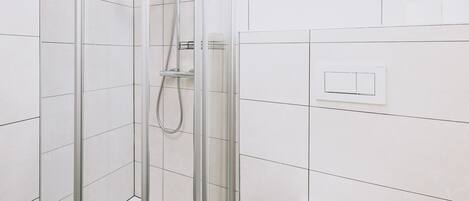 Een douche, een haardroger, handdoeken, toiletpapier