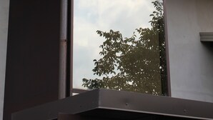 Un bâtiment moderne doté d’une grande baie vitrée et d’une structure en métal.