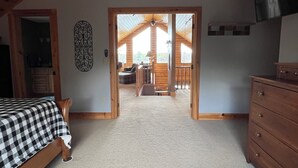Une chambre à coucher avec un lit, une commode et une vue sur un balcon.