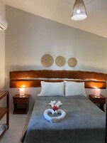 Habitación de hotel impecable con una cama grande, dos mesitas de noche con lámparas, un cabecero de madera y detalles decorativos en la pared.