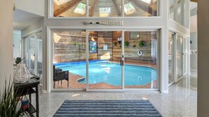 A pool area with a wooden wall and a sign reading "BEACH HOUSE."