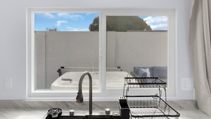 A modern bathroom with a large window, a built-in sink, and a towel rack. - Entire house near Monterey with Jacuzzi (Salinas)