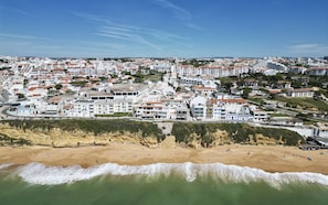 Uma cidade costeira com praia, edifícios brancos e céu claro.
