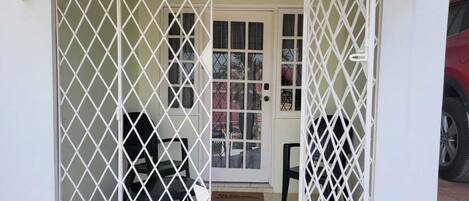 A gated entrance with a door and a small porch area.