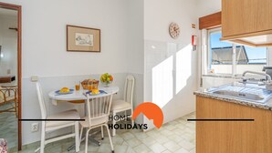 Una cocina moderna con una mesa de comedor, sillas y una mesa lista para el desayuno.