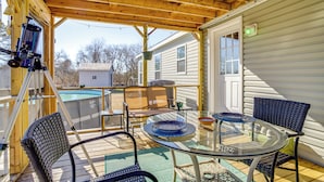 A covered outdoor patio with a glass table, wicker chairs, and a telescope. - 1 Mi to Boat Ramp: Peaceful Deal Island Home! (Deal Island Historic District)