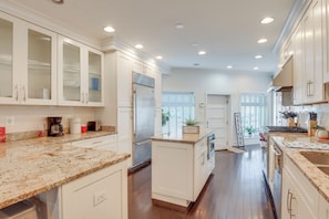 A modern kitchen with white cabinetry, granite countertops, and stainless steel appliances. - Rooftop Patio w/ View: Baltimore Retreat (Baltimore)